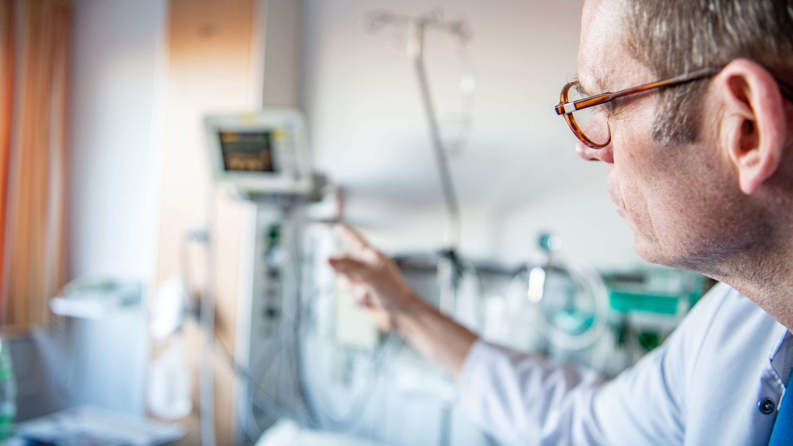 Arzt mit medizinischen Geräten im Hintergrund