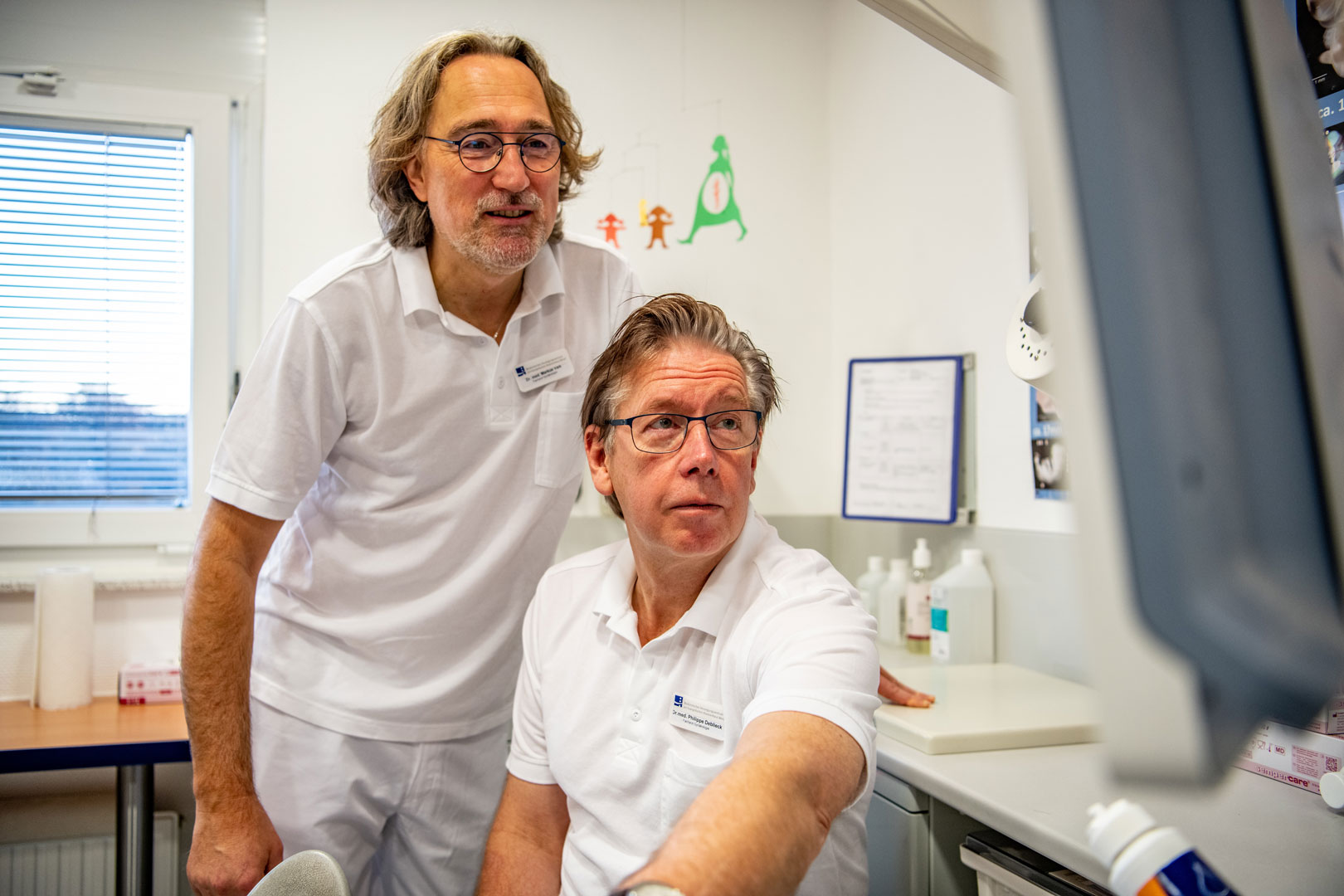 Zwei Ärzte die auf einem Bildschirm blicken